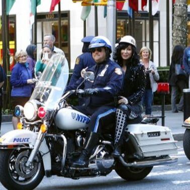 An NYPD officer and, for some reason, Cher, on a motorcycle together